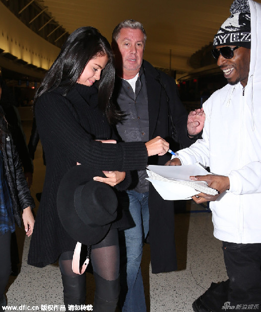 组图:赛琳娜黑丝袜秀美腿 甜笑为粉丝签名